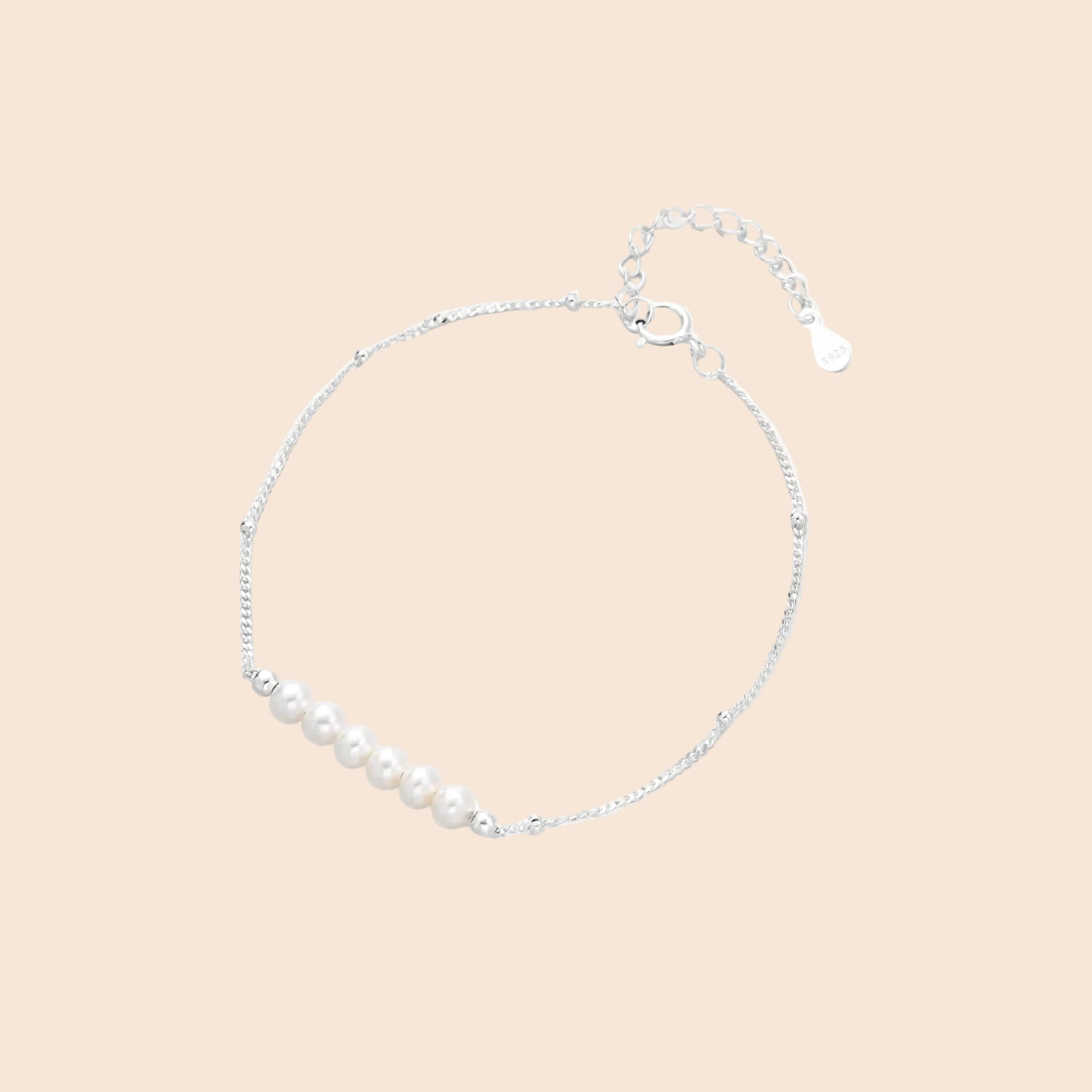 Delicate rhodium-plated silver chain bracelet with row of small baroque pearls centered on white background.
