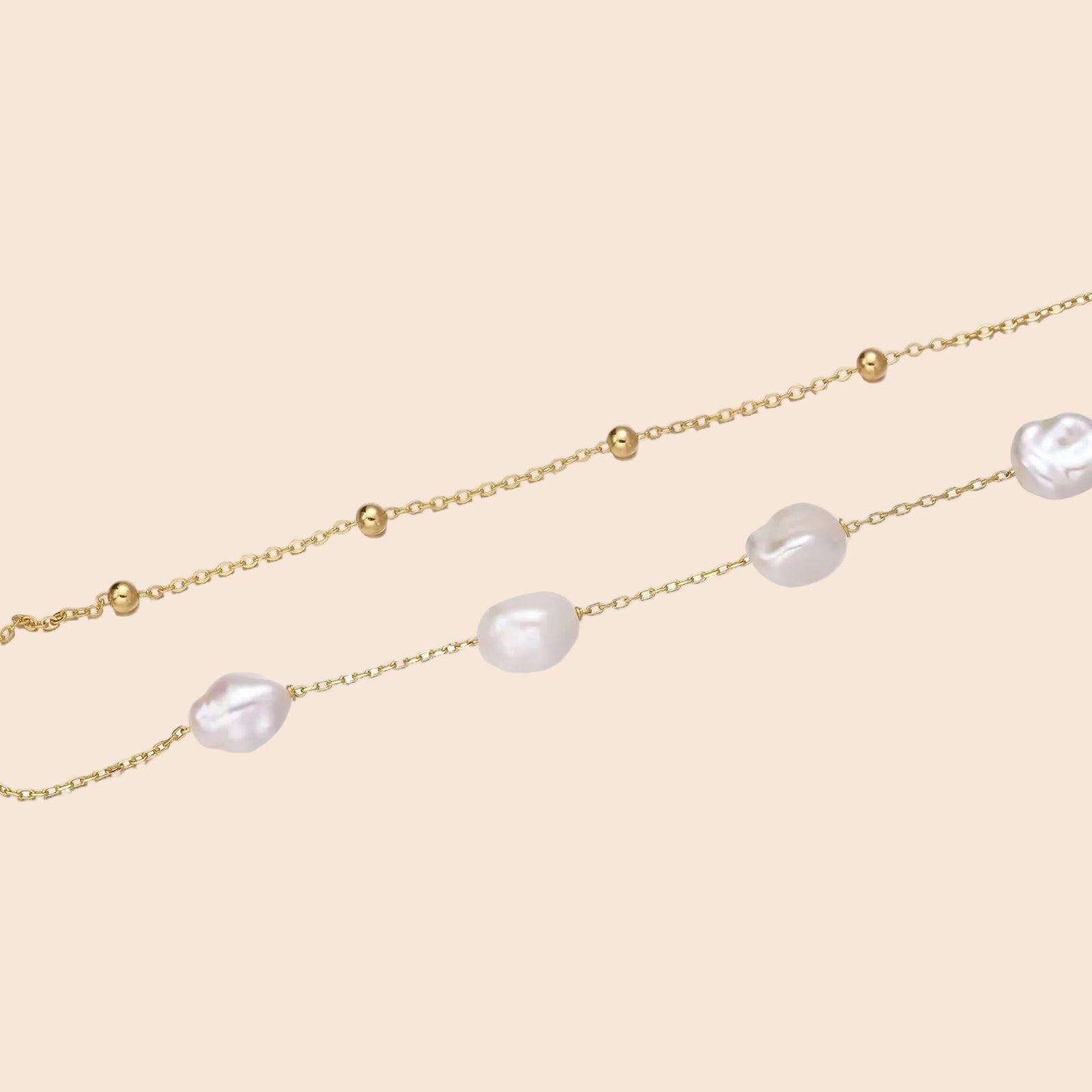 Double-strand gold bracelet with irregular baroque pearls and smooth freshwater pearls on cream background.