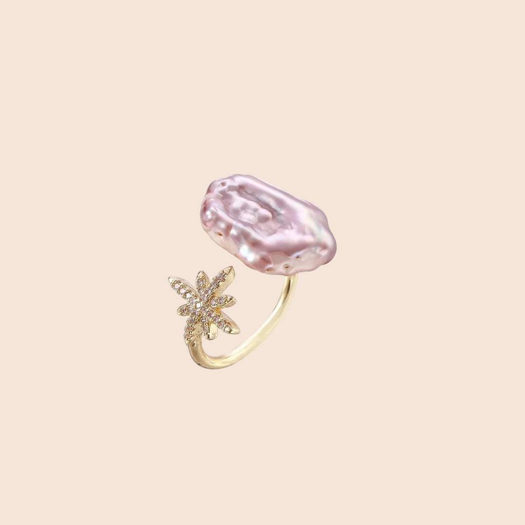 Adjustable gold ring with pink baroque freshwater pearl and crystal-studded star charm on white background