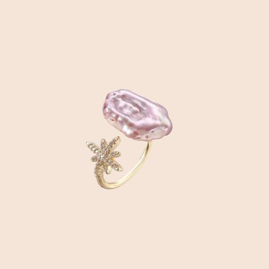Adjustable gold ring with pink baroque freshwater pearl and crystal-studded star charm on white background