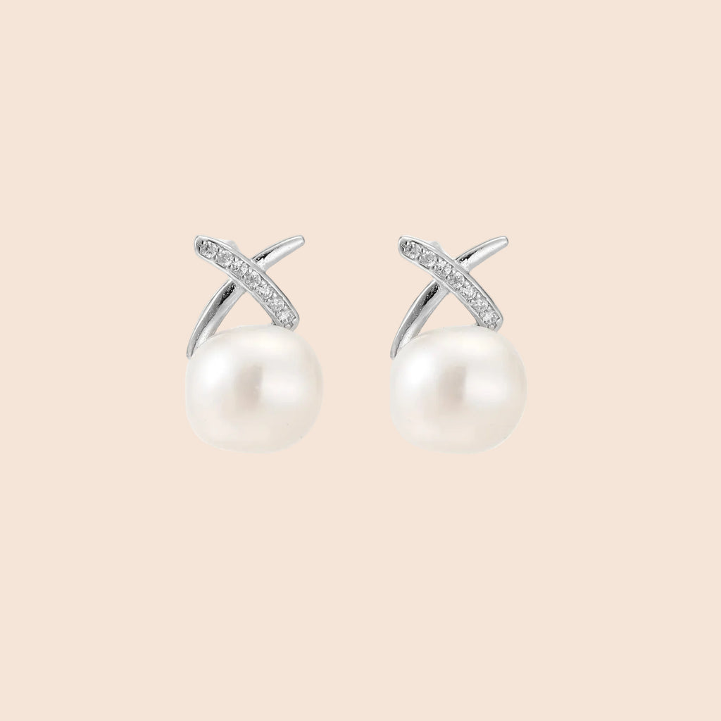Rhodium-plated silver stud earrings with sparkling X design above lustrous round freshwater pearls on white background.