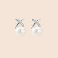 Rhodium-plated silver stud earrings with sparkling X design above lustrous round freshwater pearls on white background.