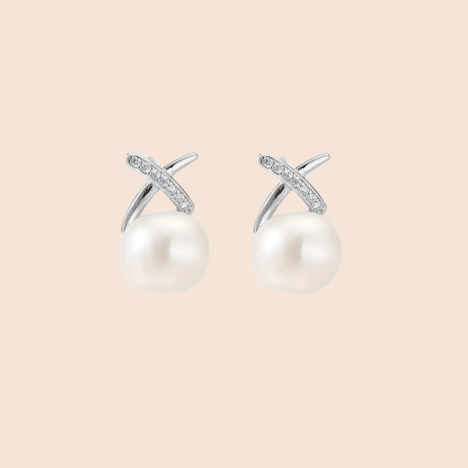 Rhodium-plated silver stud earrings with sparkling X design above lustrous round freshwater pearls on white background.