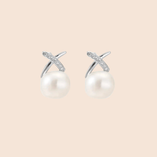Rhodium-plated silver stud earrings with sparkling X design above lustrous round freshwater pearls on white background.