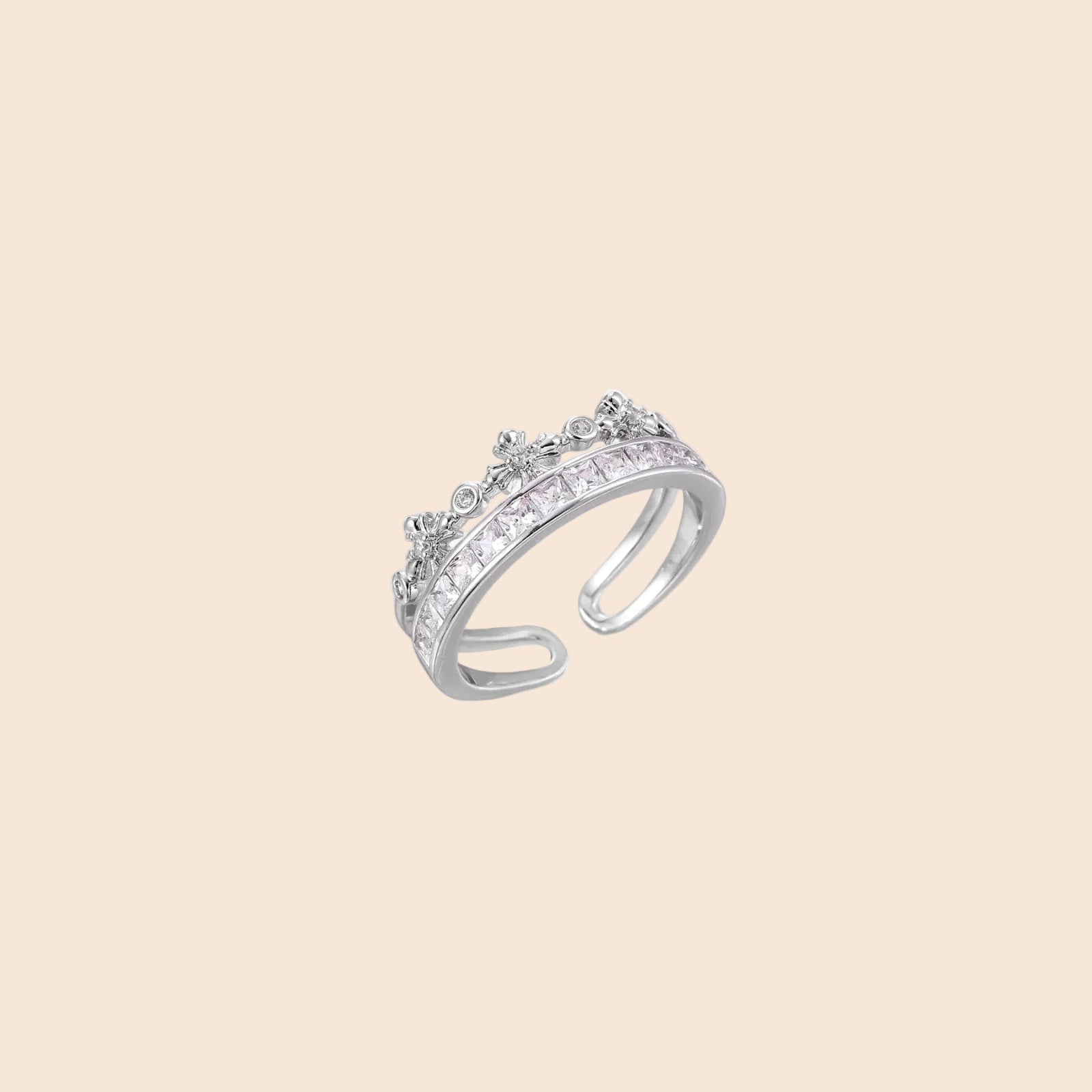 Silver-toned adjustable crown ring with channel-set square zirconia stones and delicate floral details on white background