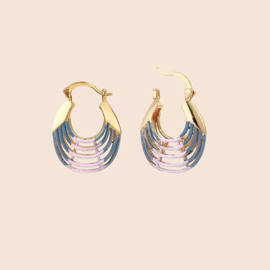 Gold hoop earrings with gradient blue-to-pink enamel in ribbed fan design on beige background