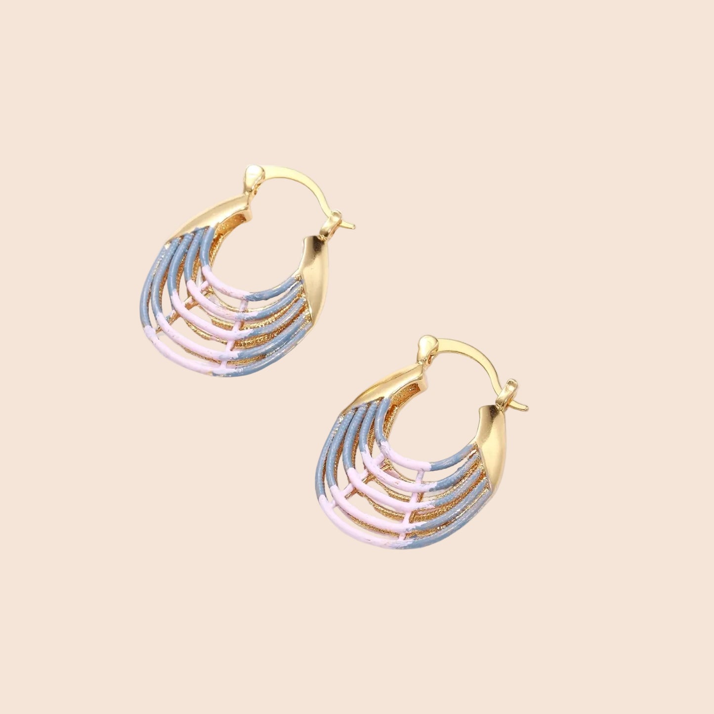 Gold hoop earrings with gradient blue-to-pink enamel in ribbed fan design on beige background