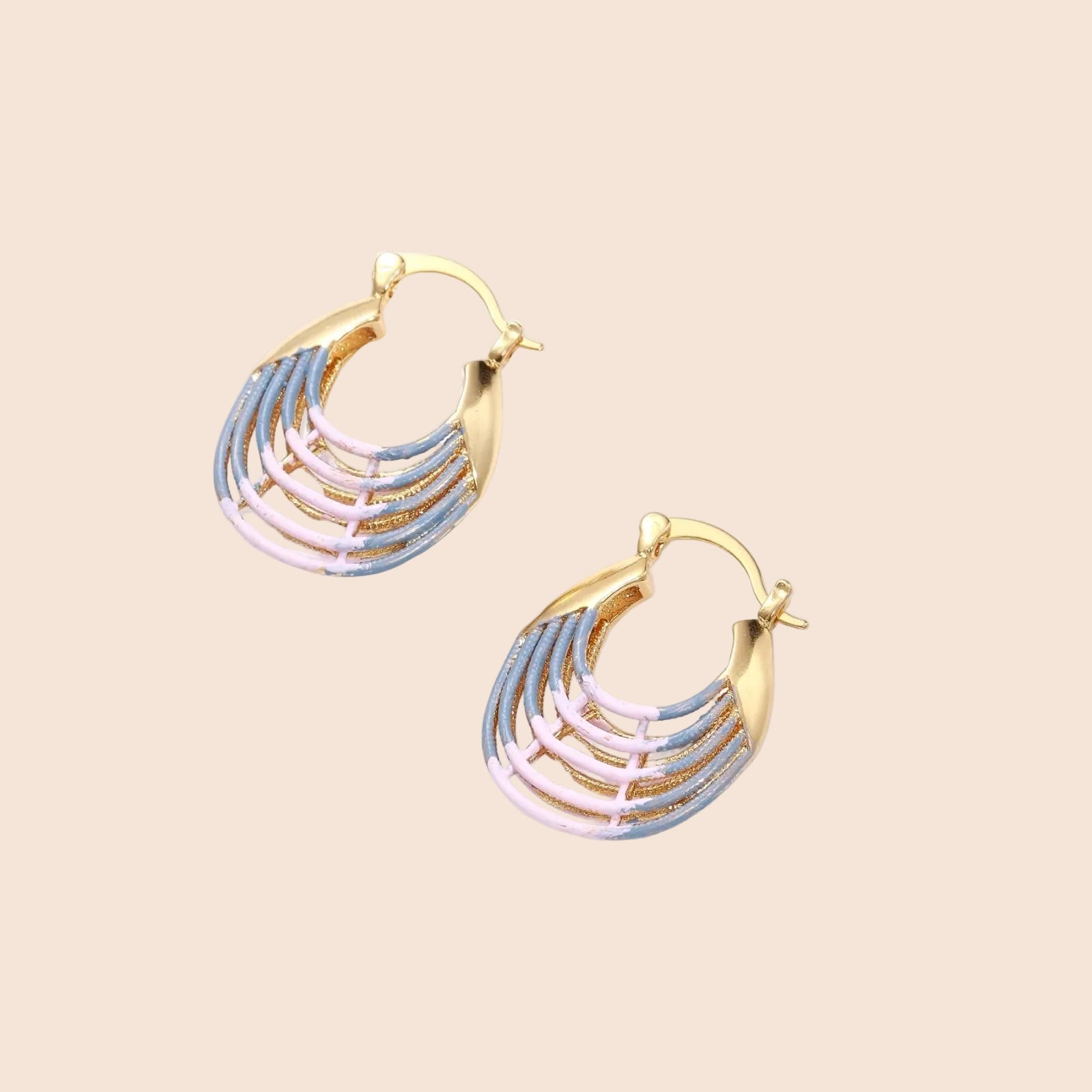 Gold hoop earrings with gradient blue-to-pink enamel in ribbed fan design on beige background