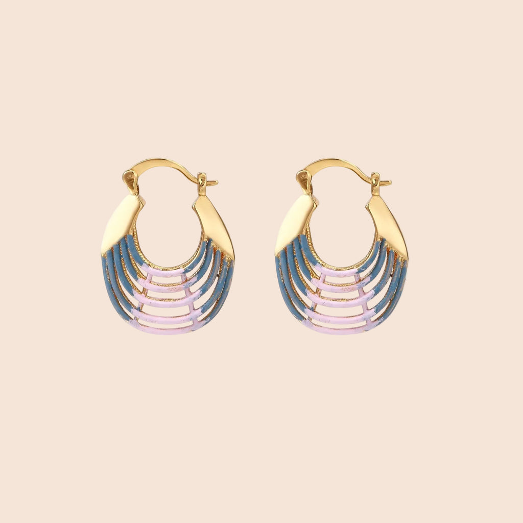 Gold hoop earrings with gradient blue-to-pink enamel in ribbed fan design on beige background
