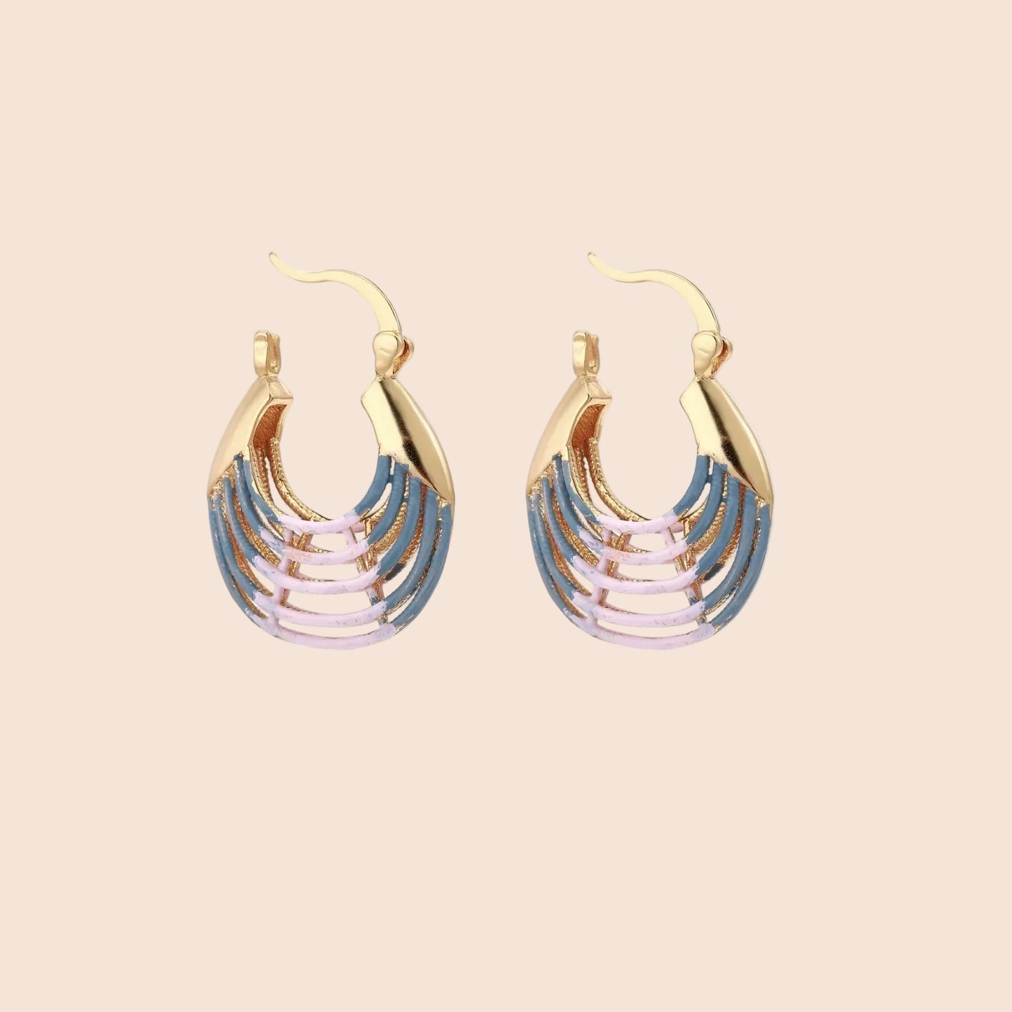 Gold hoop earrings with gradient blue-to-pink enamel in ribbed fan design on beige background
