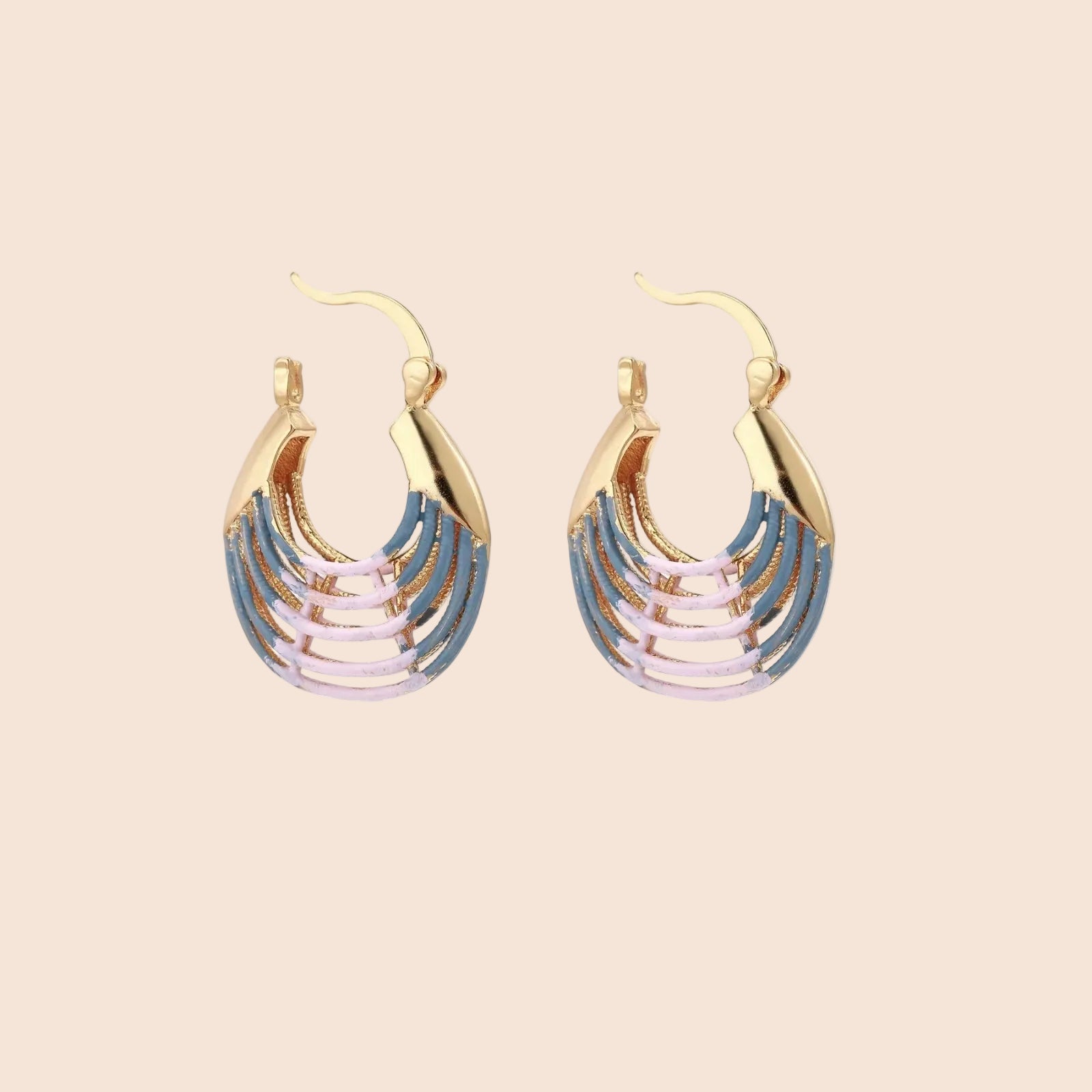 Gold hoop earrings with gradient blue-to-pink enamel in ribbed fan design on beige background