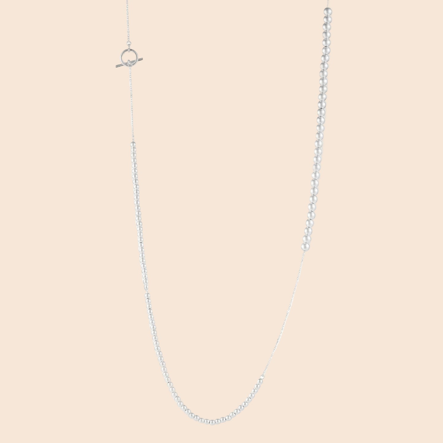 Long sterling silver beaded necklace with graduated sphere design, toggle clasp, and delicate chain extension on white background