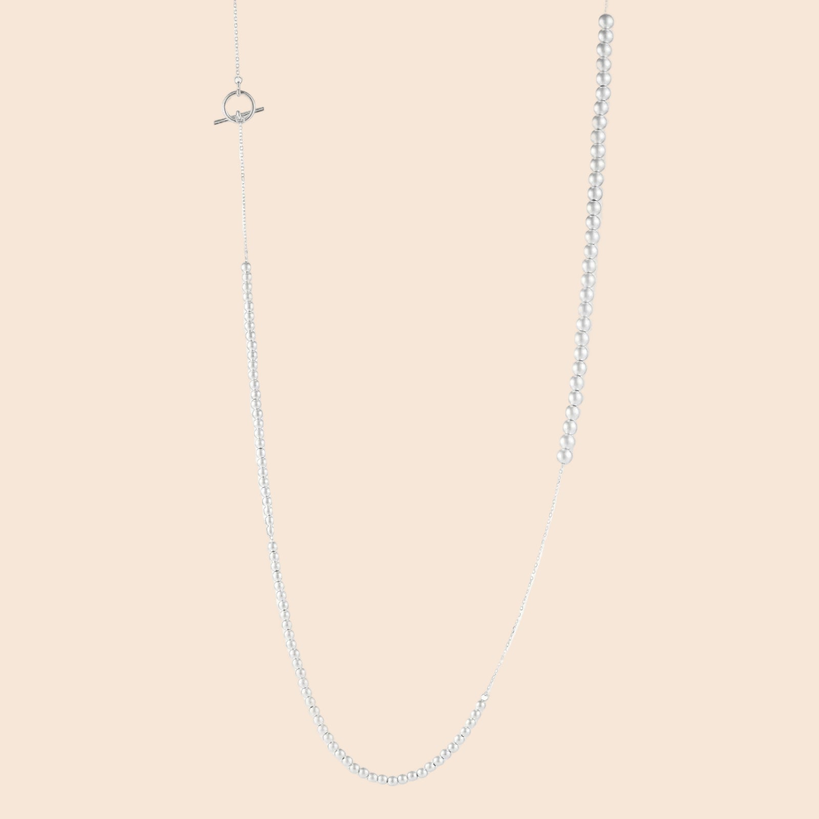 Long sterling silver beaded necklace with graduated sphere design, toggle clasp, and delicate chain extension on white background