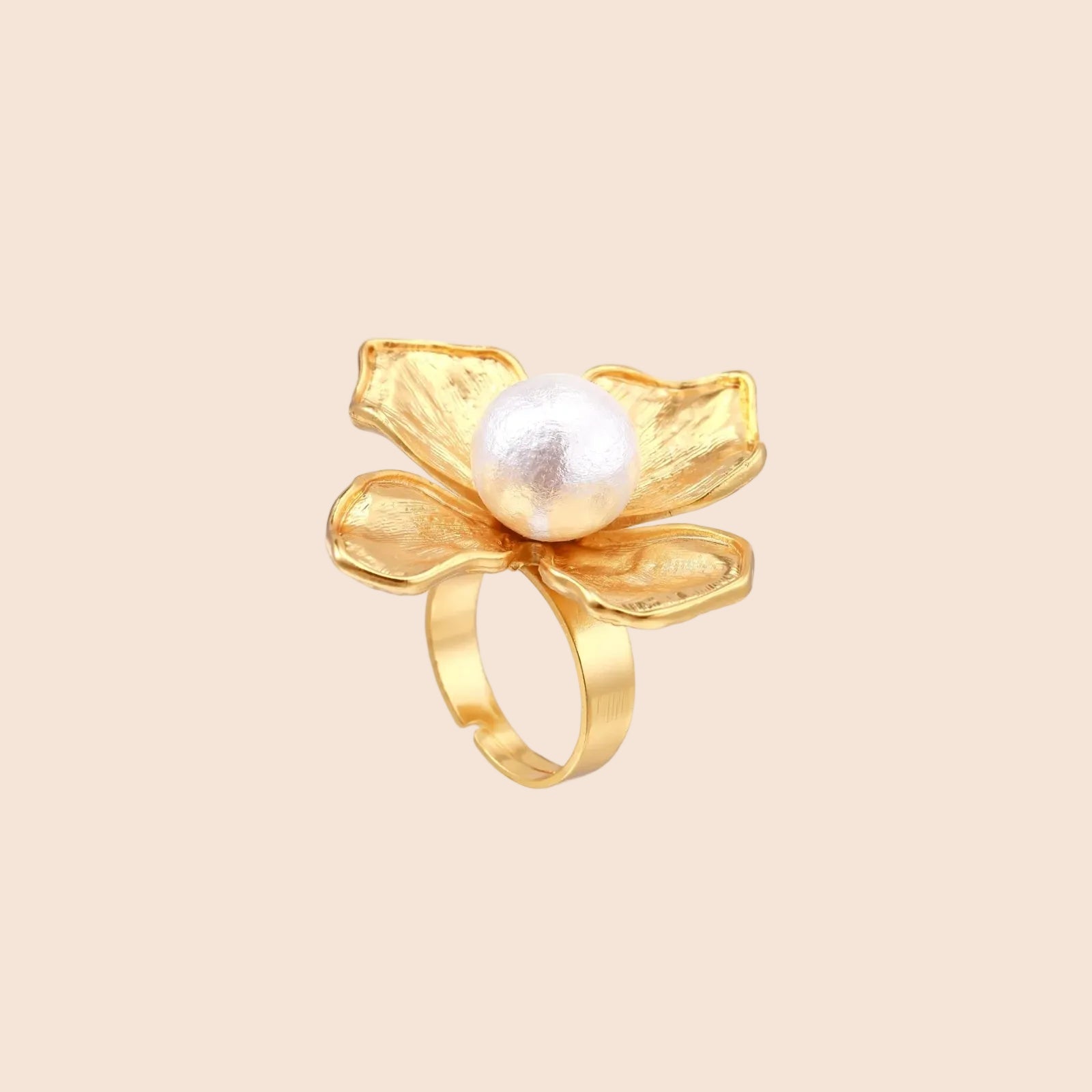 Gold-plated flower ring with textured petals and white cotton pearl center on cream background