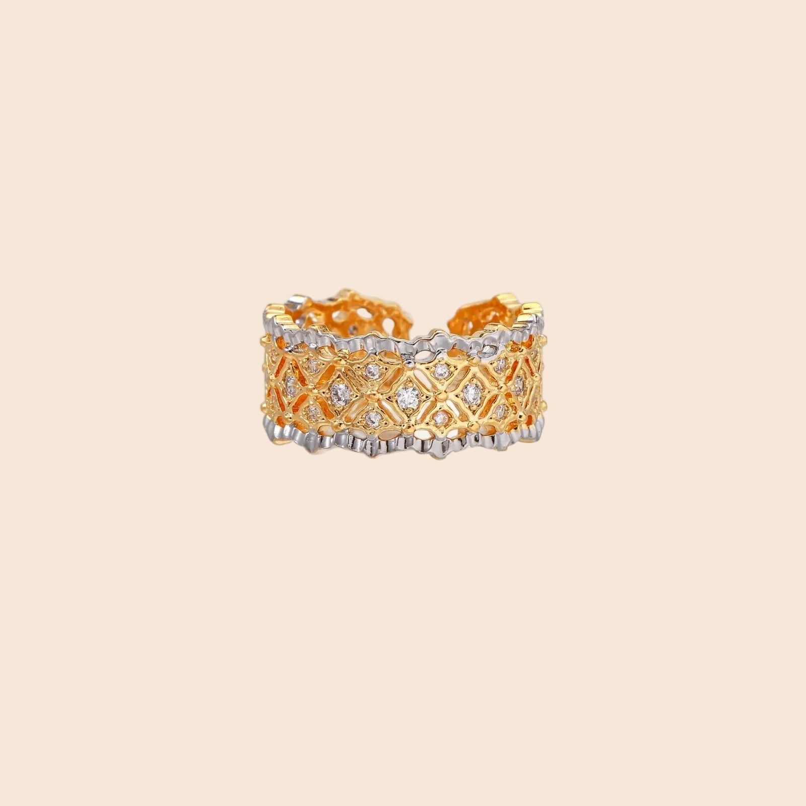 Two-tone ring with geometric lattice pattern in gold and silver finish with crystal accents on beige background