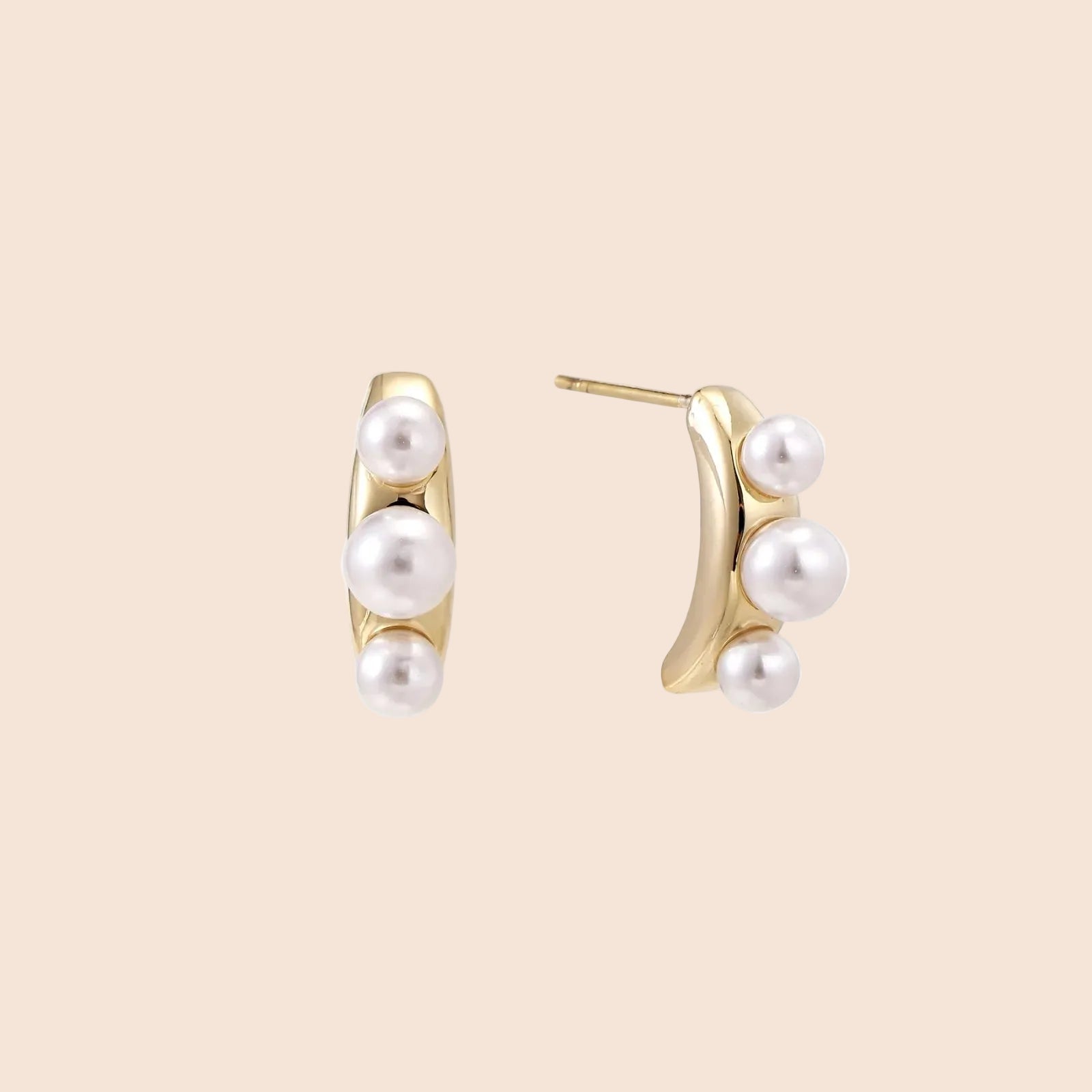 14K gold-plated curved stud earrings with three white freshwater pearls aligned vertically on cream background