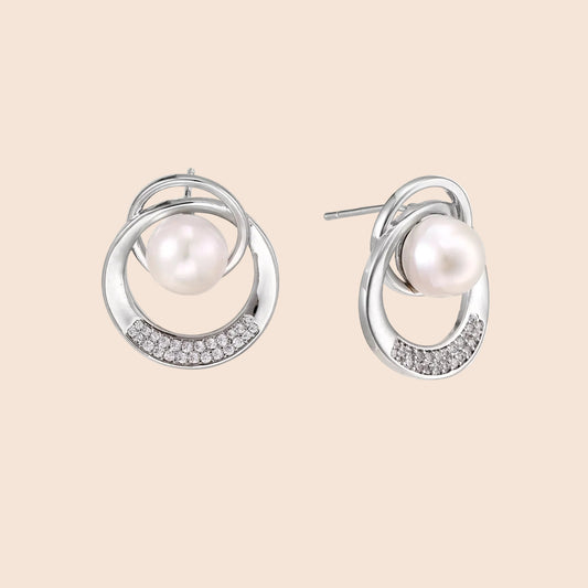 White gold-plated brass earrings with circular design, freshwater pearl center, and diamond accents