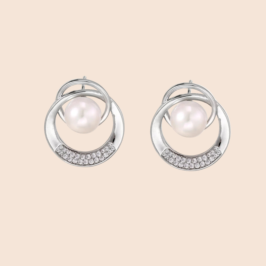 White gold-plated brass earrings with circular design, freshwater pearl center, and diamond accents