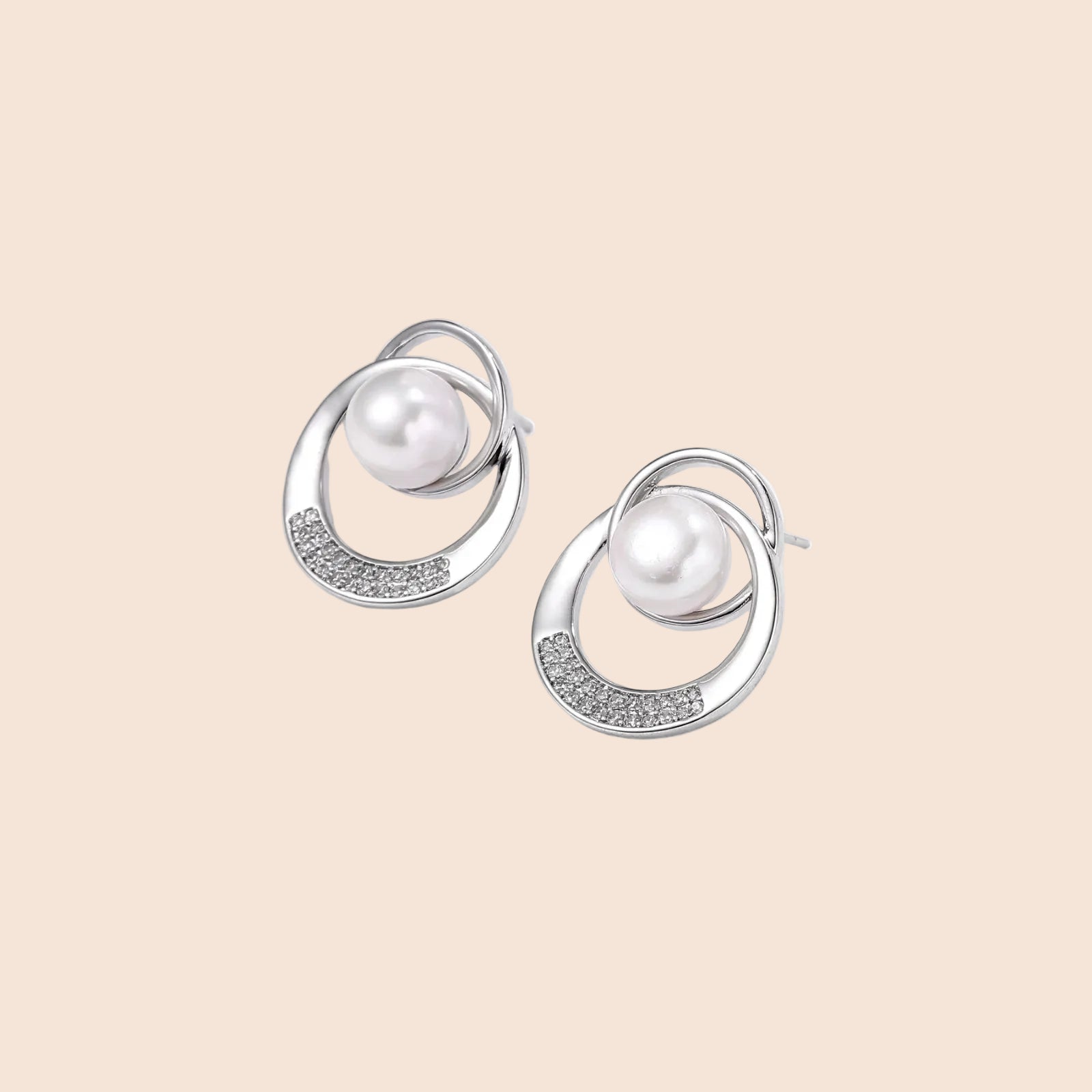 White gold-plated brass earrings with circular design, freshwater pearl center, and diamond accents