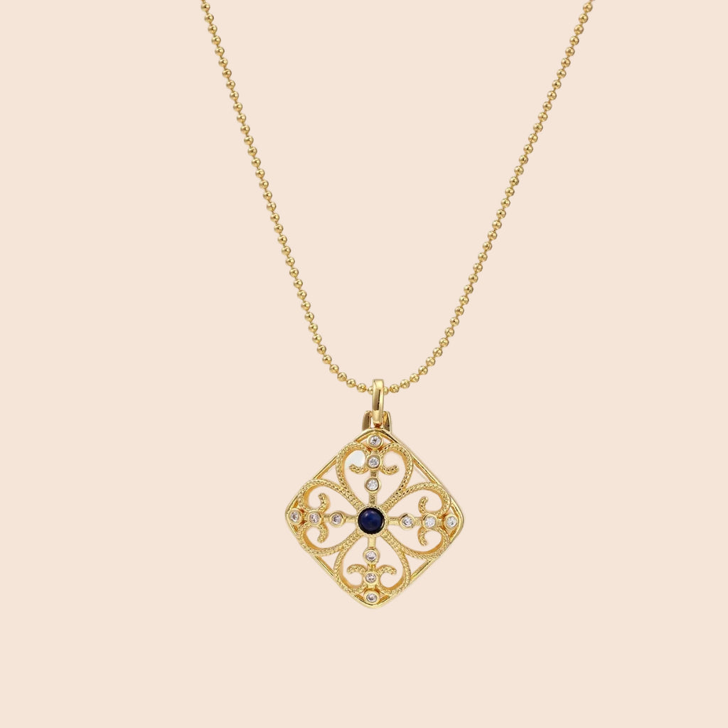 Gold filigree pendant with quatrefoil design, deep blue lapis lazuli center, clear crystal accents on ball chain
