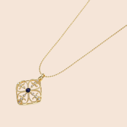 Gold filigree pendant with quatrefoil design, deep blue lapis lazuli center, clear crystal accents on ball chain