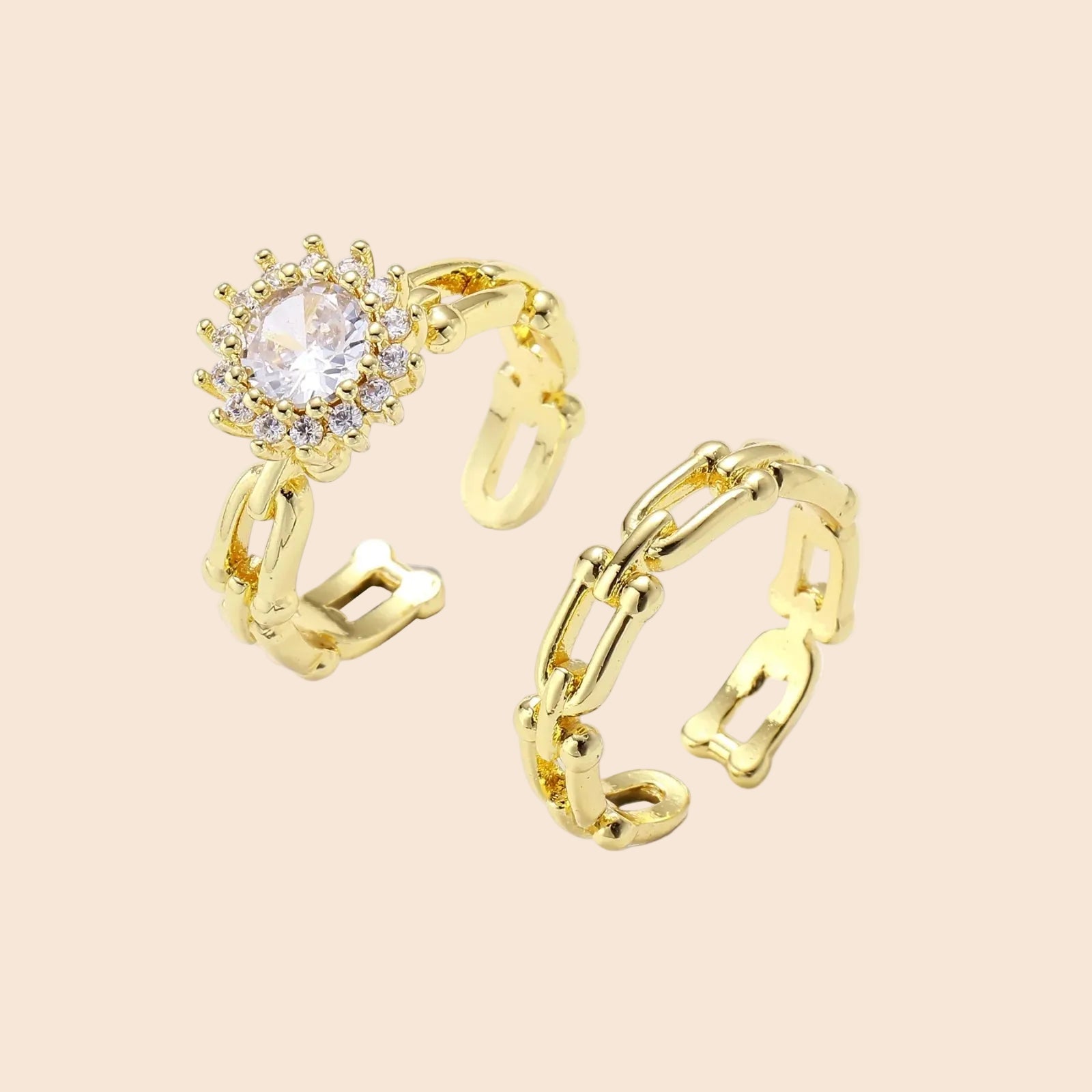 Two adjustable gold rings: chain-link band and halo-style ring with cubic zirconia stones on cream background