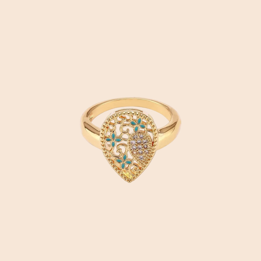 Teardrop-shaped gold-plated ring with turquoise enamel flowers and crystal pavé detail on cream background