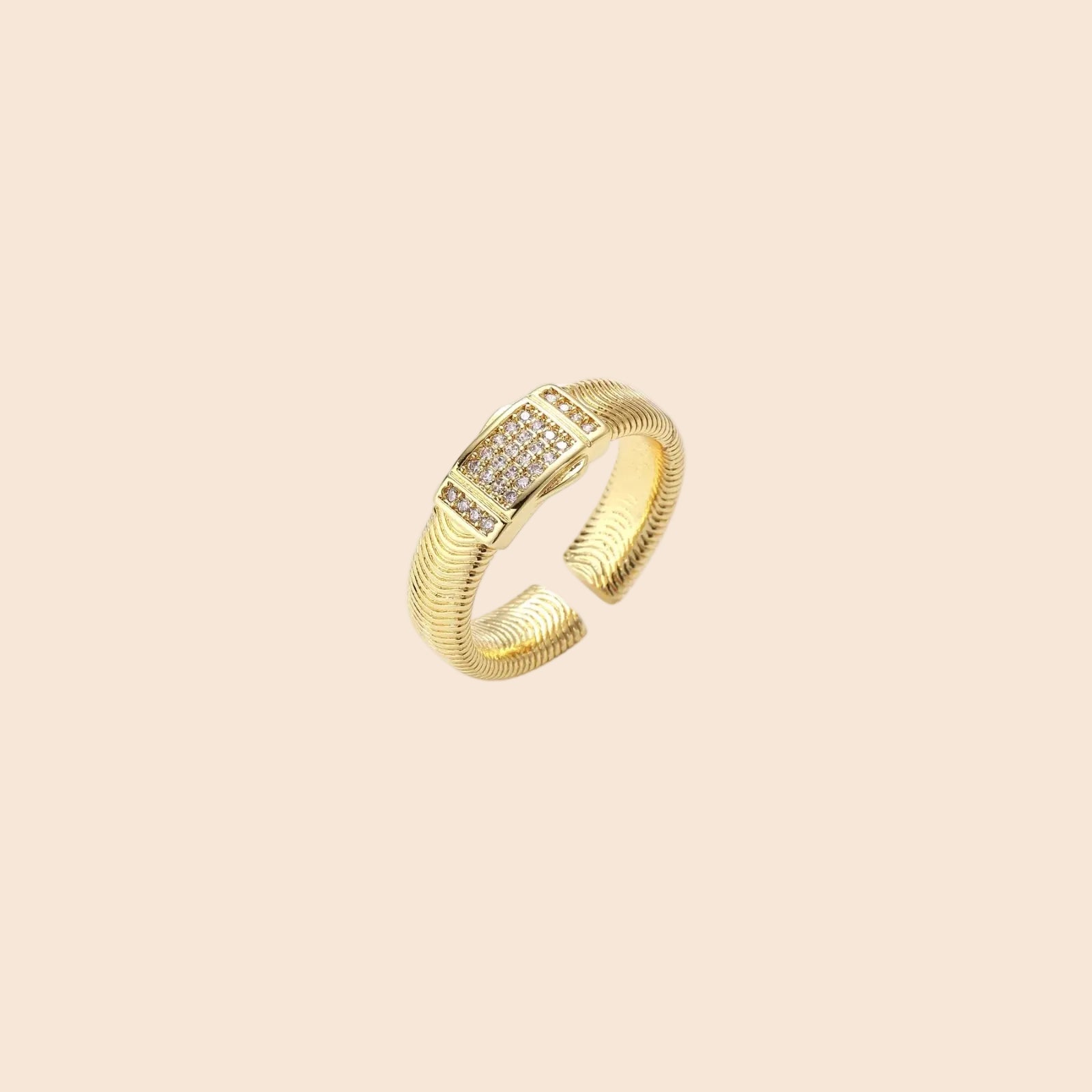 Gold-plated adjustable ring with ribbed band and rectangular pavé cubic zirconia panel on white background.