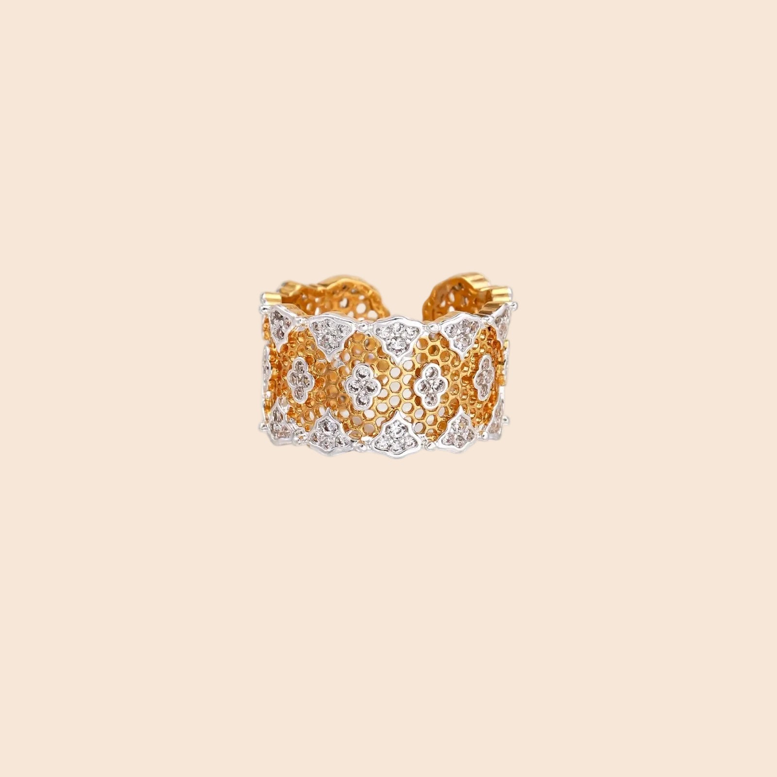 Two-tone gold and silver lattice ring with clover pattern and crystal accents on white background