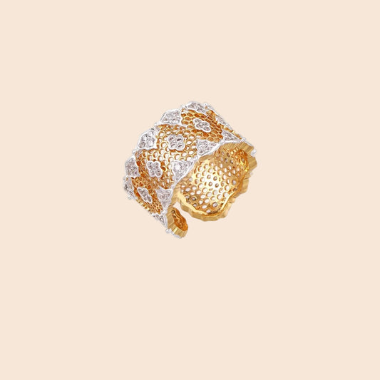 Two-tone gold and silver lattice ring with clover pattern and crystal accents on white background