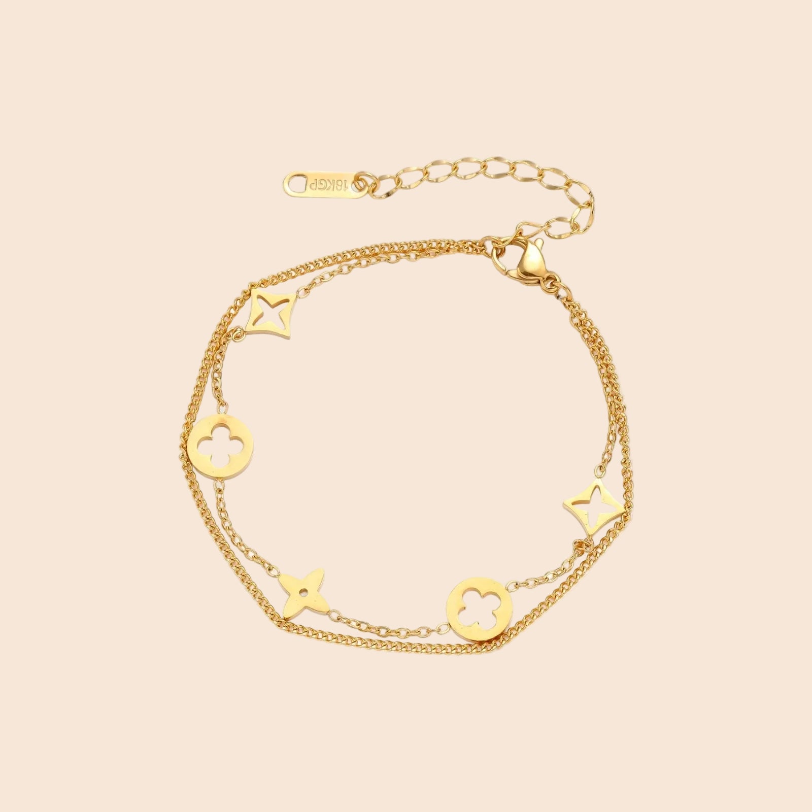 Double-layer gold-plated bracelet with quatrefoil and star charms on cream background, 18K gold finish.