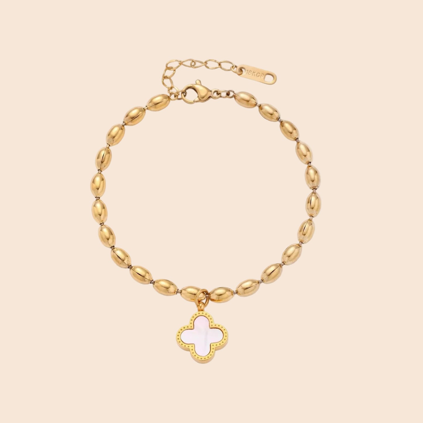 18K gold-plated oval bead chain bracelet with quatrefoil clover charm featuring mother of pearl inlay on cream background