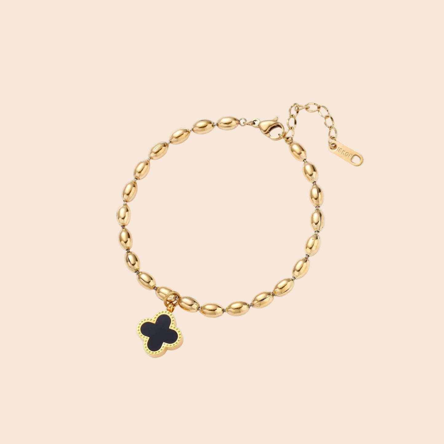 18K gold-plated oval bead chain bracelet with quatrefoil clover charm featuring mother of pearl inlay on cream background