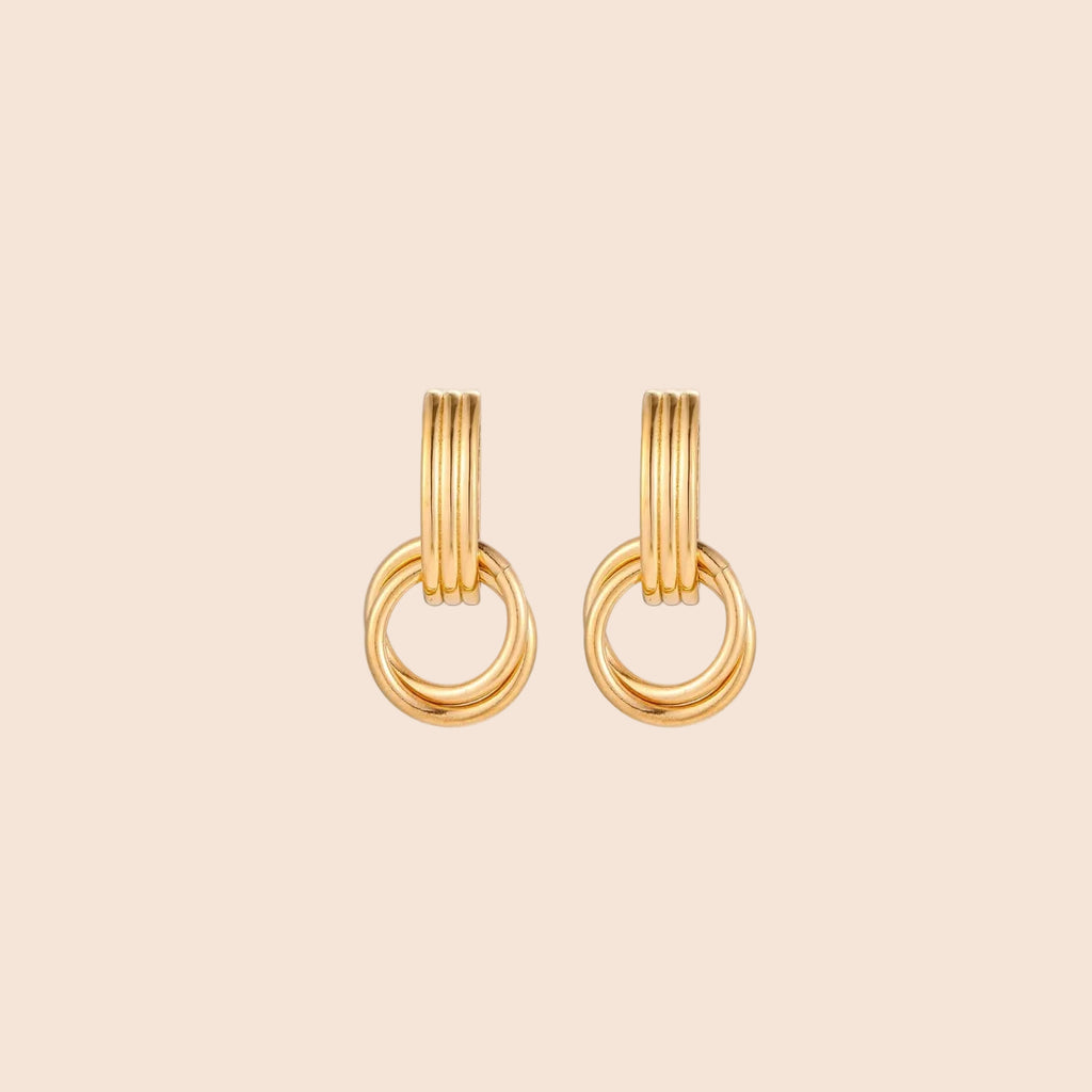 Gold stud earrings with vertical ridged bar connecting to triple interlocking circular rings on white background