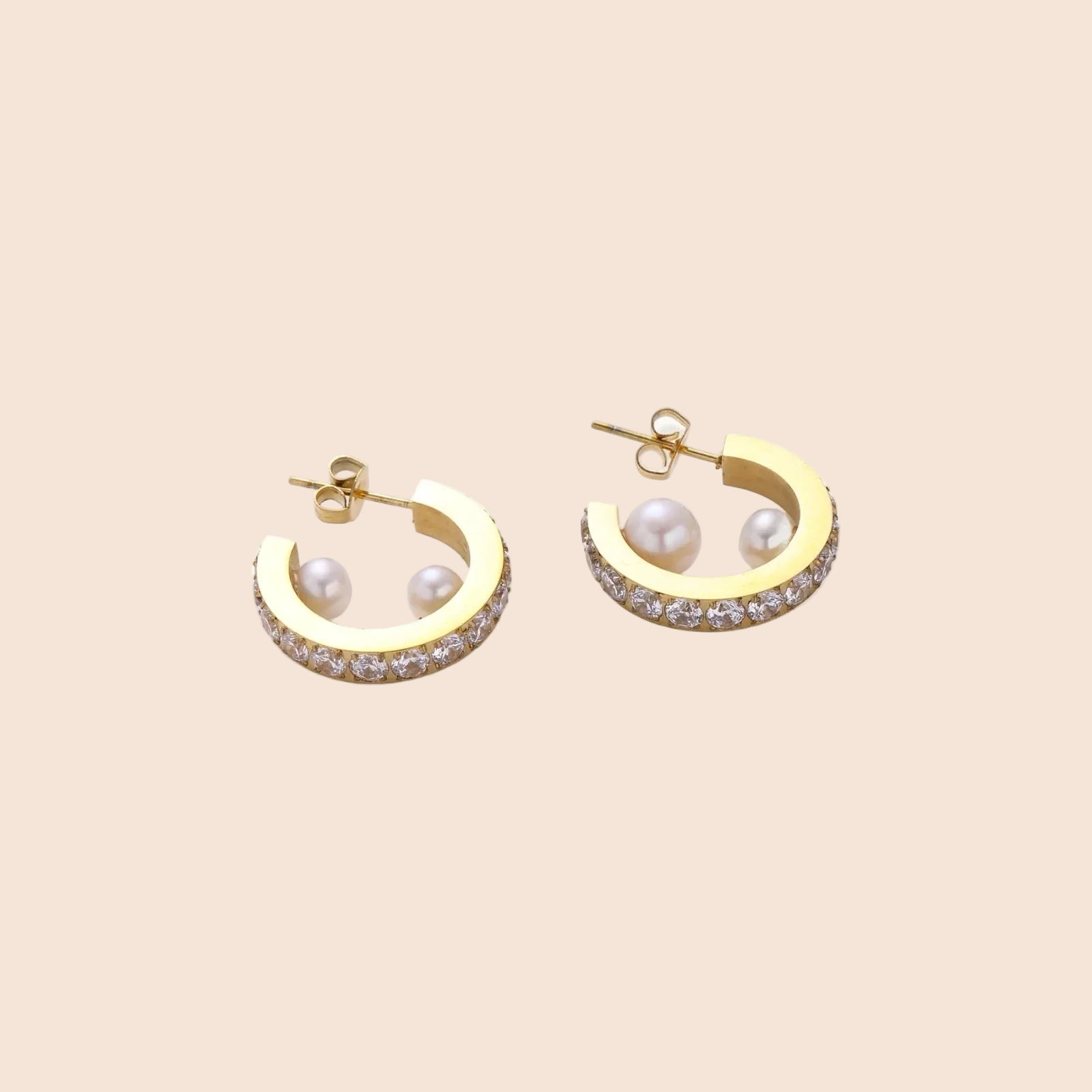 Gold pavé hoop earrings with two freshwater pearls nestled inside the curved design, featuring crystal-studded outer edge.