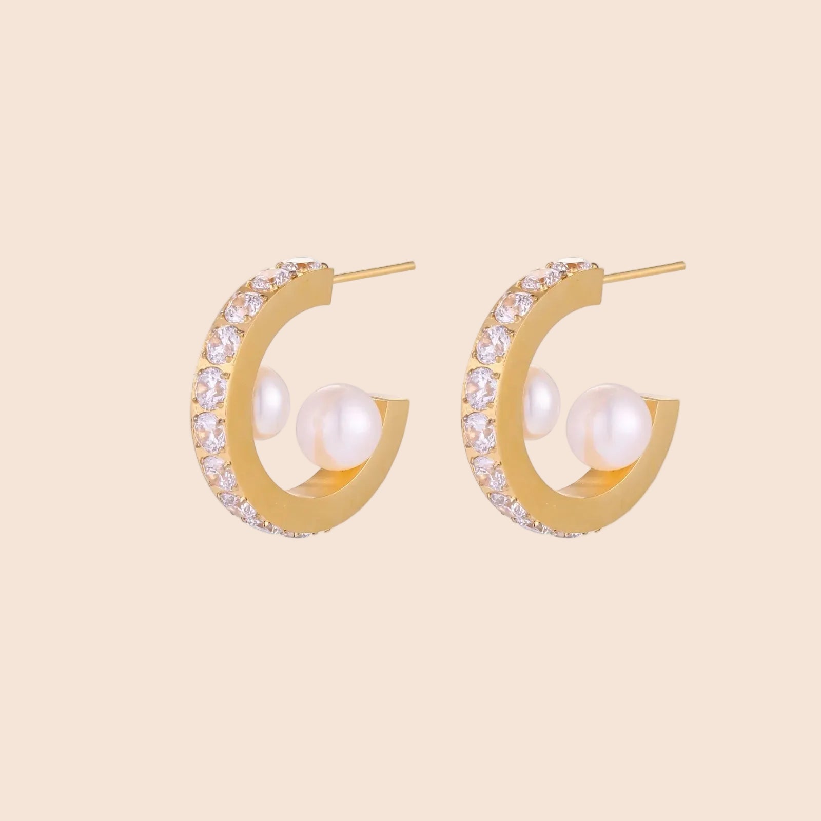 Gold pavé hoop earrings with two freshwater pearls nestled inside the curved design, featuring crystal-studded outer edge.