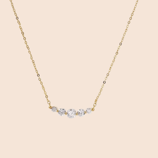 Delicate 14K gold-plated necklace with five graduated zirconia stones arranged in a curved arc on fine chain