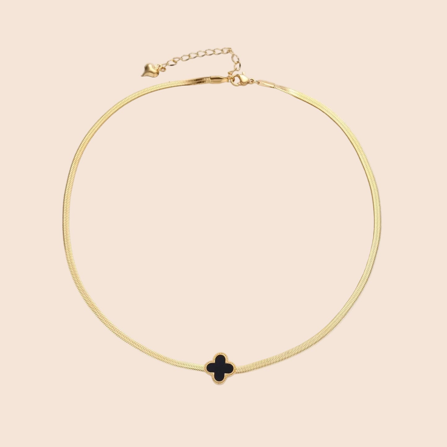 Dainty 18K gold-plated herringbone chain necklace with black enamel quatrefoil clover pendant on white background