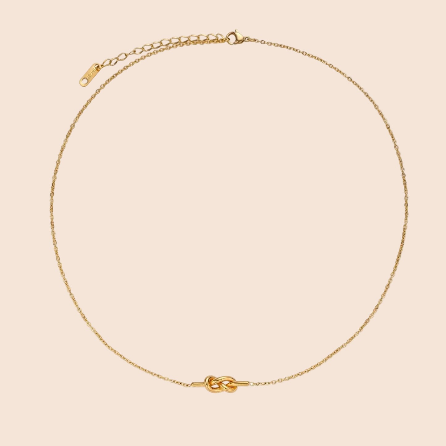 Dainty 18K gold plated necklace with infinity knot pendant on delicate chain against white background