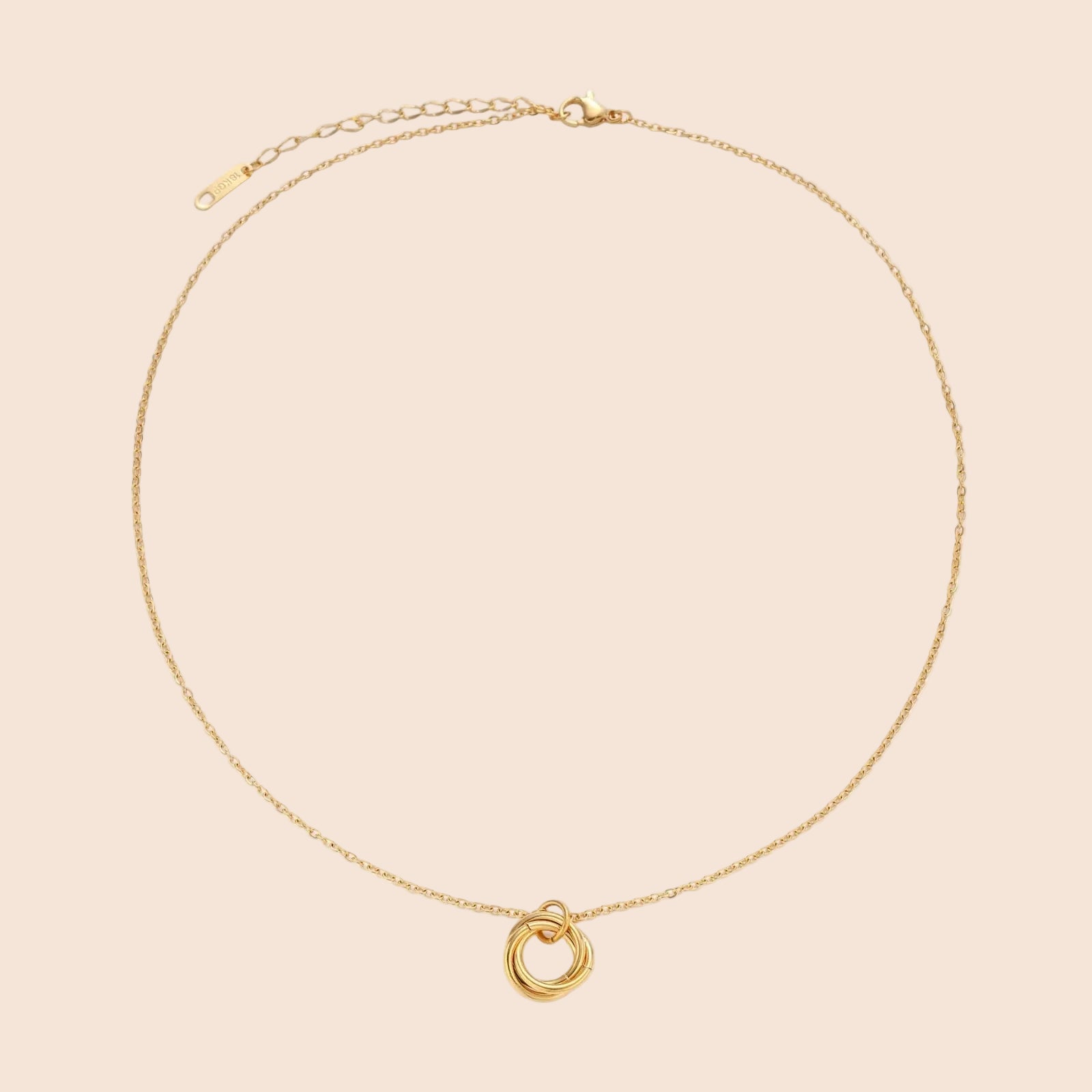 Delicate gold-plated necklace with three interlocking circle rings forming a minimalist knot pendant on cream background