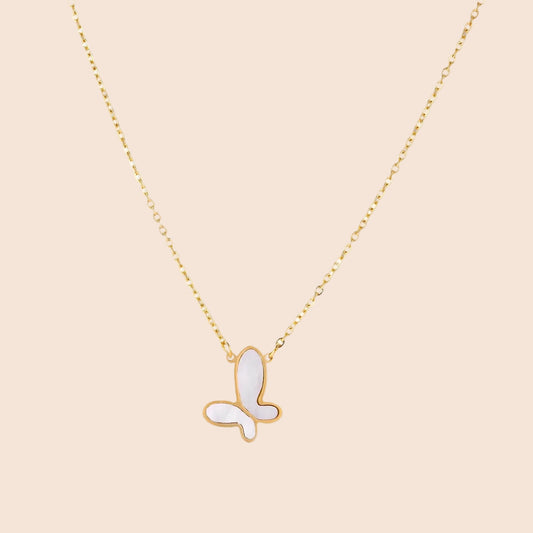Gold-plated butterfly pendant with iridescent mother of pearl inlay on delicate chain against cream background.