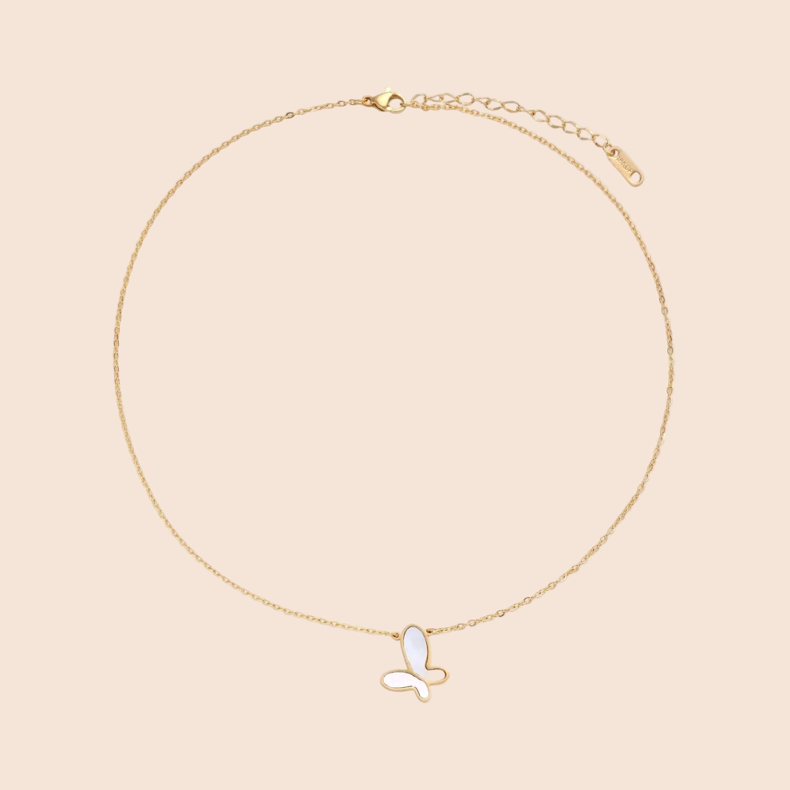 Gold-plated butterfly pendant with iridescent mother of pearl inlay on delicate chain against cream background.