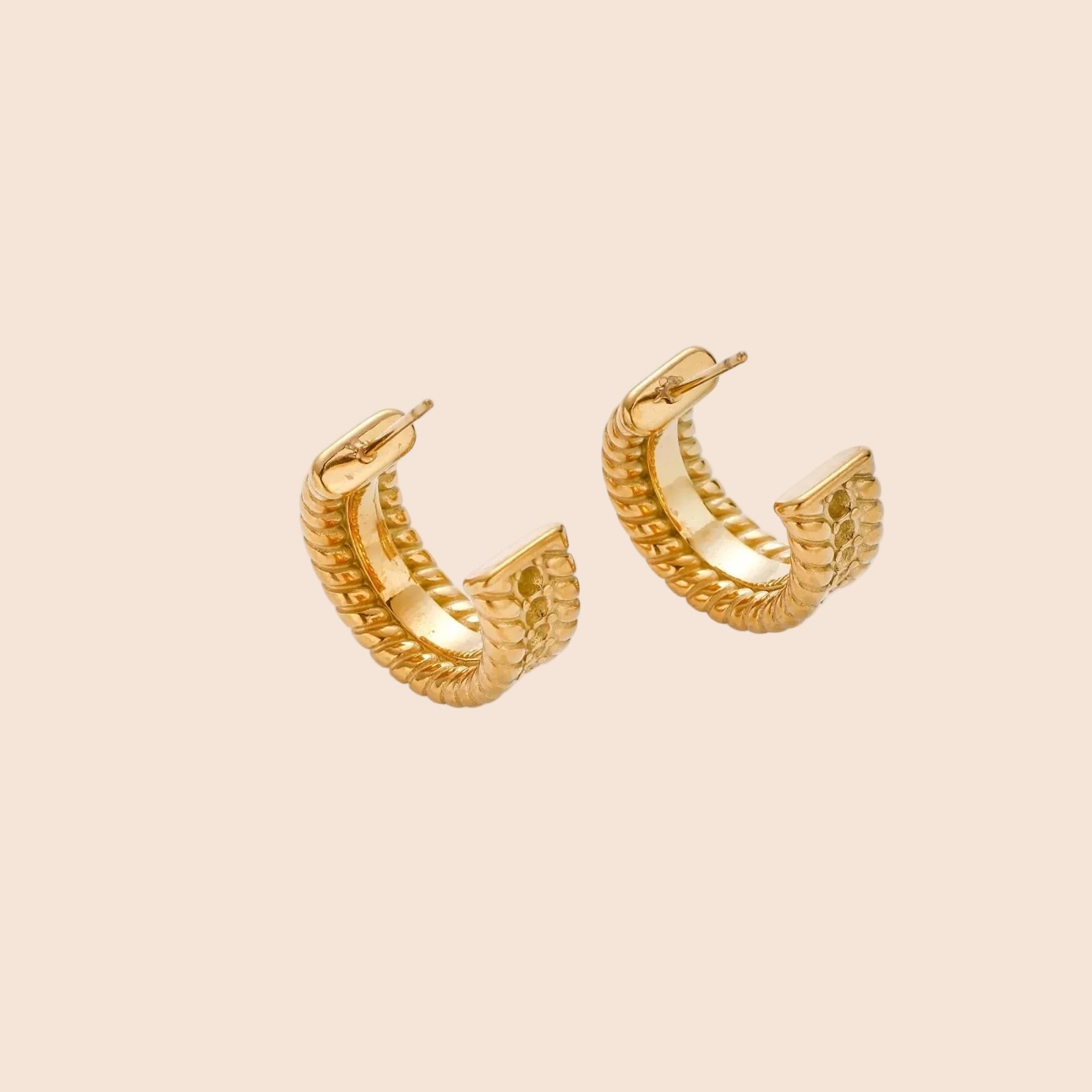Chunky gold hoops with dimensional ridged texture and 14K plated finish shown in front and side view on cream background.