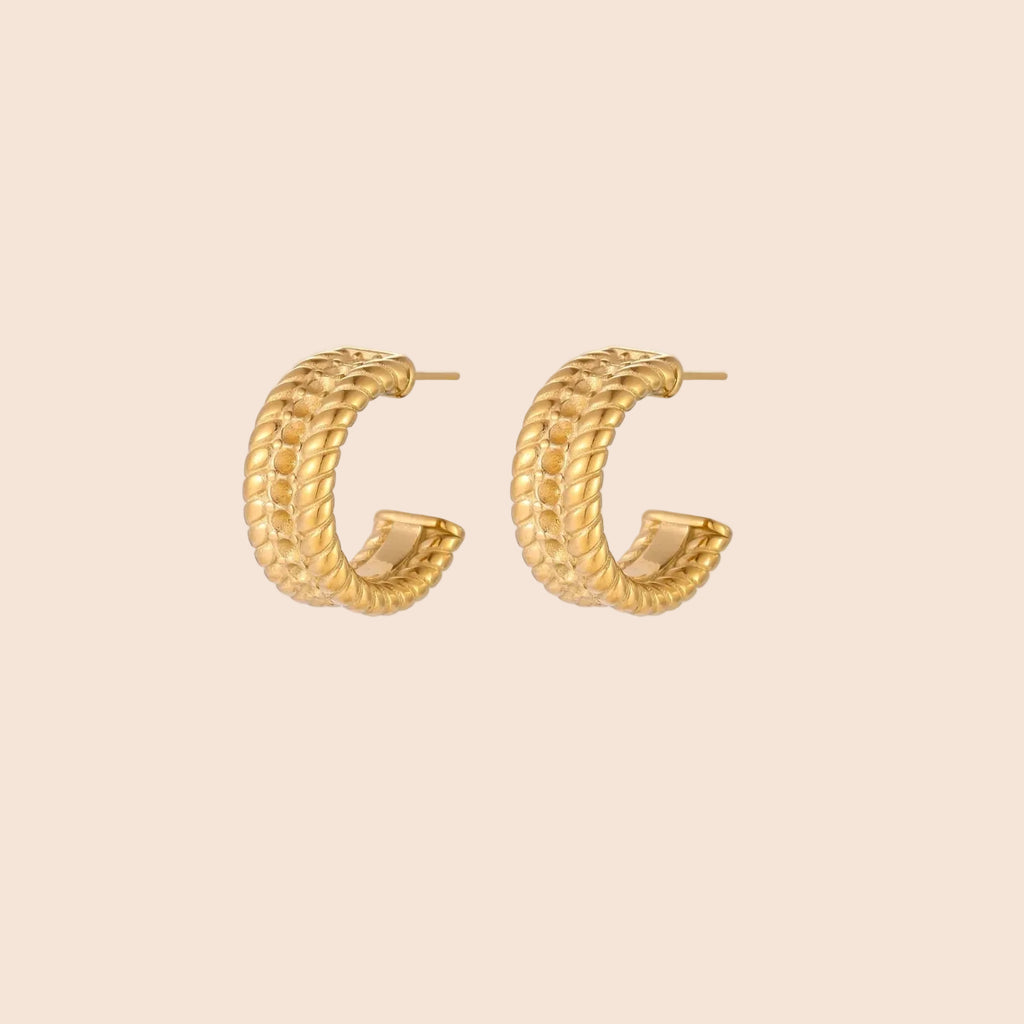 Chunky gold hoops with dimensional ridged texture and 14K plated finish shown in front and side view on cream background.